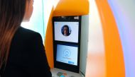 A woman uses an ATM with facial recognition technology during the presentation of the new service by CaixaBank in Barcelona on February 14, 2019. AFP / Lluis Gene 