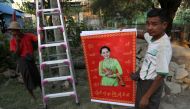 Workers put up poster of Myanmar's State Counsellor Aung San Suu Kyi ahead of the opening date of the Rakhine State Investment Fair in Ngapali beach in Thandwe, Rakhine, Myanmar February 20, 2019. Reuters/Ann Wang 