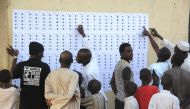 Voters check their names on the lists to vote in Maiduguri on February 23, 2019.  AFP / AUDU ALI MARTE

