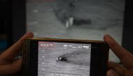 A Pakistani journalist watches a video released by Pakistan's Navy that allegedly shows an Indian submarine, on a smartphone in Islamabad on March 5, 2019. AFP / AAMIR QURESHI