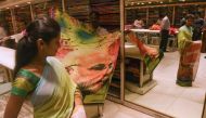 A saleswoman tries on a saree bearing the image of Indian Prime Minister Narendra Modi to show it to customer at a shop in Mumbai on February 19, 2019. AFP / Indranil Mukherjee
 
 