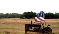 FILE PHOTO: A tattered U.S. flag flies on an old tractor in a farm field outside Sutherland Springs,Texas, U.S. November 8, 2017. Reuters/Rick Wilking