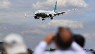 FILE PHOTO: Visitors watch as a Boeing 737 Max lands after an air display during the Farnborough Airshow, south west of London. AFP / BEN STANSALL
