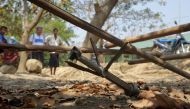 This photo taken on March 16, 2019 shows people looking at an unexploded rocket in the Mrauk U township in Rakhine. / AFP / STR 
