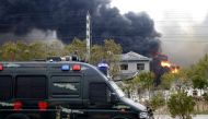 A vehicle of paramilitary police is seen near smoke following an explosion at a chemical industrial park in Xiangshui county, Yancheng, Jiangsu province, China March 21, 2019. REUTERS