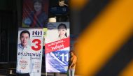 A woman walks past electoral posters displayed along a road in Bangkok on March 23, 2019, on the eve of the general election. Thais will head to polls on March 24 for a highly anticipated election -- the first since the junta wrested power in a 2014 coup.