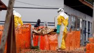 Health workers carry a newly admitted confirmed Ebola patient into the Red zone of the Ebola treatment centre in the Eastern Congolese town of Butembo in the Democratic Republic of Congo, March 28, 2019.  REUTERS/Baz Ratner