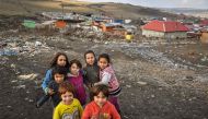 Children pose in front of makeshift shacks where they live with their families on the edge of the Pata-Rat landfill site next to Cluj-Napoca city on February 7, 2019. AFP/Daniel Mihailescu