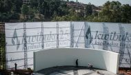 Workers clean the stage at the Genocide Memorial in Kigali, ahead of the 25th commemoration of the 1994 Genocide against the Tutsi on April 6, 2019. / AFP / Yasuyoshi CHIBA
