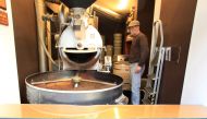 Freshly roasted coffee beans fall into a tumbler after the drum type roaster is opened by an employee at H. Schwarzenbach coffee roastery in Zurich, Switzerland December 4, 2018. (REUTERS/Arnd Wiegmann/File Photo)