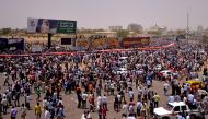 Sudanese demonstrators gather after Sudan's Defense Minister Awad Mohamed Ahmed Ibn Auf said that President Omar al-Bashir had been detained 