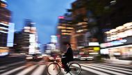 A man rides his bicycle at night in Tokyo on April 22, 2019. AFP/Charly Triballeau
 