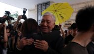 Occupy Central pro-democracy movement founder Chu Yiu-ming hugs a supporter after he had his suspended sentence on his involvement in the Occupy Central, also known as 