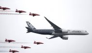 An Airbus A350 aircraft flies in formation with Britains’ Red Arrows flying display team at the Farnborough International Airshow in Farnborough, July 15, 2016. Reuters/Peter Nicholls