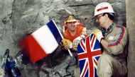 Tunnel workers Philippe Cozette from France (R) and Graham Fagg from England shake hands while holding national flags, during the historic breakthrough in the Channel Tunnel on December 1, 1990. AFP