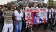 People carry a banner depicting Liberia's President George Weah as they march during a protest to voice discontent towards the presidency of Weah, whose policies they see as having failed to curb economic decline and mitigate corruption, in Monrovia, Libe