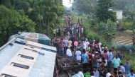 Bangladeshi onlookers gather around a derailed train after a bridge collapse in Kulaura on June 24, 2019. AFP / STR