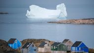Icebergs float behind the town of Kulusuk in Greenland on August 19, 2019.  AFP / Jonathan NACKSTRAND