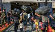 Refugees and migrants board a ship at the port of Mytilene, on the island of Lesbos on September 2, 2019, as hundreds of migrants leave Lesbos, helping to ease overcrowding at the Moria camp.  AFP / STRINGER