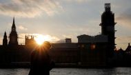 A man stands on the banks of River Thames across from the Houses of Parliament in Westminster in central London, on March 27, 2019. AFP/Tolga Akmen