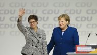Annegret Kramp-Karrenbauer greets delegates while she stands next to Angela Merkel after she has been elected as new CDU party leader in Hamburg on December 7, 2018. Abdülhamid Ho?ba?/ Anadolu Agency