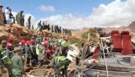 Members of the security forces search for bodies in the wreckage of bus at the banks of the Damchan river near the city of Errachidia, in the El Khank region in southern Morocco following a flood-related accident that left at least six people dead, on Sep
