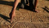 Manoel Kanunxi, chief of the Manoki indigenous people, points to the location of his people's land that was burnt, on a map drawn in dirt, on the outskirts of Brasnorte, in Mato Grosso state, Brazil August 27, 2019. Reuters/Amanda Perobelli