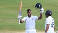 Indian cricketer Mayank Agarwal (L) raises his bat after scoring a century (100 runs) during the second day's play of the first Test match between India and South Africa at the Dr. Y.S. Rajasekhara Reddy ACA-VDCA Cricket Stadium in Visakhapatnam on Octobe