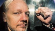 Julian Assange gestures from the window of a prison van as he is driven out of Southwark Crown Court in London on May 01, 2019. AFP / Daniel Leal-Olivas