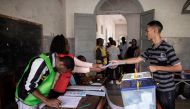 A Mozambican man receives his ballot at a voting station in a school during the Mozambican General Elections on October 15, 2019 in Maputo, Mozambique. / AFP / GIANLUIGI GUERCIA