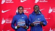 Kenya's Brigid Kosgei (L) smiles after winning the women's 2019 Bank of America Chicago Marathon with the World Record, next to the men's winner Kenya's Lawrence Cherono (R) on October 13 2019 in Chicago, Illinois. AFP / Kamil Krzaczynski