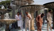 Men cool off from the heatwave as they shower at a water fountain along a road in Karachi, May 25, 2018. Reuters /  Akhtar Soomro