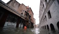 A man walks in a flooded street in Venice, during 