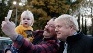 Britain's Prime Minister Boris Johnson poses for a selfie photograph with a member of the public during a General Election campaign trail stop at Thornton-Cleveleys railway station in north-west England on November 15, 2019. AFP / POOL / Frank Augstein