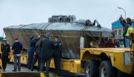 Official stand near a submarine used to transport drugs illegally in Aldan, northwestern Spain, on November 27, 2019.  AFP / Lalo R. VILLAR