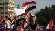 Iraqi demonstrators wave national flags as they take part in an anti-government demonstration in the capital Baghdad's Tahrir Square, on December 6, 2019. AFP / AHMAD AL-RUBAYE