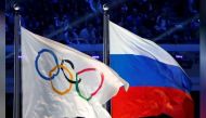 The Russian national flag (R) and the Olympic flag are seen during the closing ceremony for the 2014 Sochi Winter Olympics, Russia, February 23, 2014. REUTERS/Jim Young/File Photo