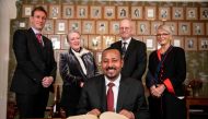 Ethiopia's Prime Minister and this year's Nobel Peace Prize Laureate Abiy Ahmed Ali (C) signs the Nobel Protocol at his arrival in Oslo, Norway, on December 9, 2019; behind (From L) members of the Norwegian Nobel Peace Prize comitee Asle Toje, chairwoman 