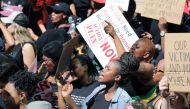 Women hold placards as they protest against gender-based violence, outside the Johannesburg Stock Exchange in Sandton, Johannesburg, South Africa, September 13, 2019. Reuters/Marius Bosch