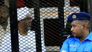 Sudan's former president Omar al-Bashir sits inside a cage during a hearing of the verdict. Sudan, December 14, 2019. REUTERS/Mohamed Nureldin Abdallah
