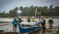 Fishermen carry a boat to higher ground in Baybay, eastern Samar on December 24, 2019, after typhoon Phanfone hit the central Philippines.   AFP / Alren BERONIO