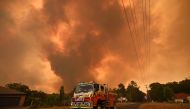 Firetrucks are seen stationed on a road as a bushfire burns in Bargo, southwest of Sydney on December 21, 2019. (AFP / PETER PARKS)