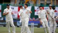England's James Anderson (3rdL) celebrates with teammates after the dismissal of South Africa's Kagiso Rabada (R) during the third day of the second Test cricket match between South Africa and England at the Newlands stadium in Cape Town on January 5, 202
