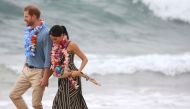 British Prince Harry walks with his wife Meghan Duchess of Sussex as they meet the local community at Bondi Beach in Sydney on October 19, 2018. AFP / David Moir