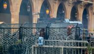 An anti-government protester climbs the police barricades during clashes with security forces in the central downtown district of the Lebanese capital Beirut near the parliament headquarters on January 18, 2020. / AFP / ANWAR AMRO