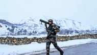 A security personnel walks on a road as he patrols near a site of a gunbattle between suspected militants and government forces at Khrew area of Pampore in Pulwama district, south of Srinagar on January 21, 2020. AFP / Tauseef Mustafa 