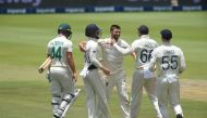 England's Mark Wood (C) celebrates with teammates after the dismissal of South Africa's Dane Paterson (L) during the third day of the fourth Test cricket match between South Africa and England at the Wanderers Stadium in Johannesburg on January 26, 2020. 