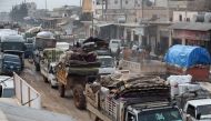 A convoy of trucks transporting the families and belongings of displaced Syrians drives through Hazano in the northern countryside of Idlib, after hundreds of people fled on January 28, 2020 its southern countryside towards areas further north near the bo