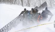 Rescue workers carry victims after an avalanche hit a group near a ski resort in Nasu town, north of Tokyo. Kyodo/via REUTERS

