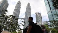 Tourists wearing masks pass by Petronas Twin Towers in Kuala Lumpur, Malaysia, January 31, 2020. REUTERS/Lim Huey Teng
